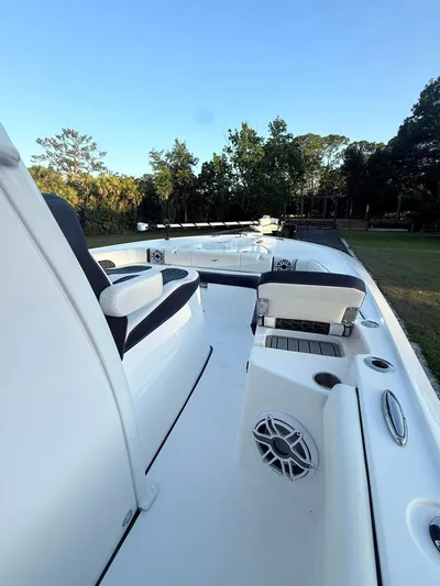  Yacht Photos Pics 2025 Tidewater 3100 Carolina Bay boat deck with seating and speaker, surrounded by trees.