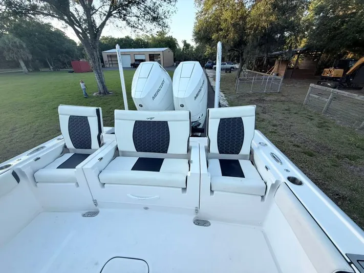  Yacht Photos Pics 2025 Tidewater 3100 Carolina Bay boat with three cushioned seats and dual outboard motors.