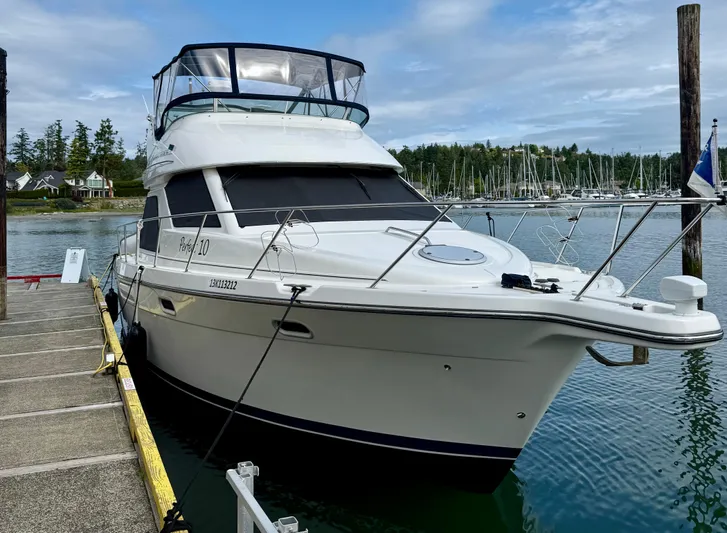 Perfect Ten Yacht Photos Pics 1999 Bayliner 3788 Command Bridge Motoryacht docked at a marina, surrounded by calm waters.