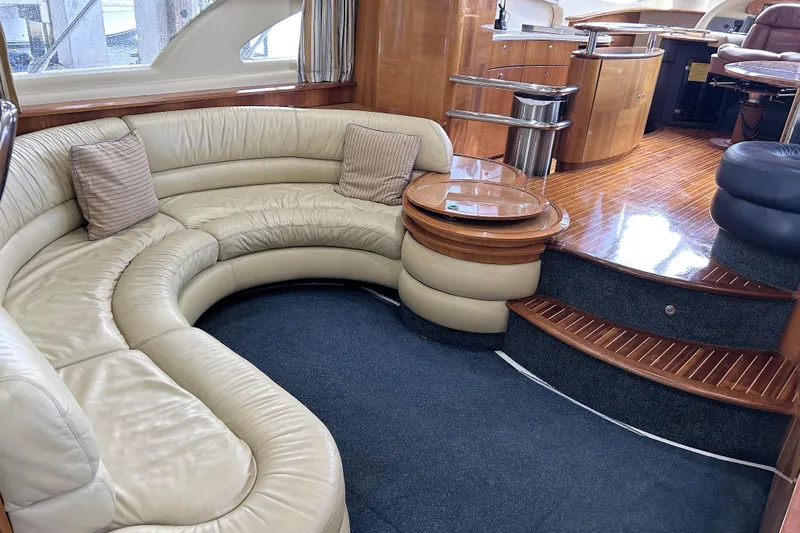  Yacht Photos Pics Luxurious interior of a 2003 Azimut 55 yacht with curved leather seating and wooden flooring.