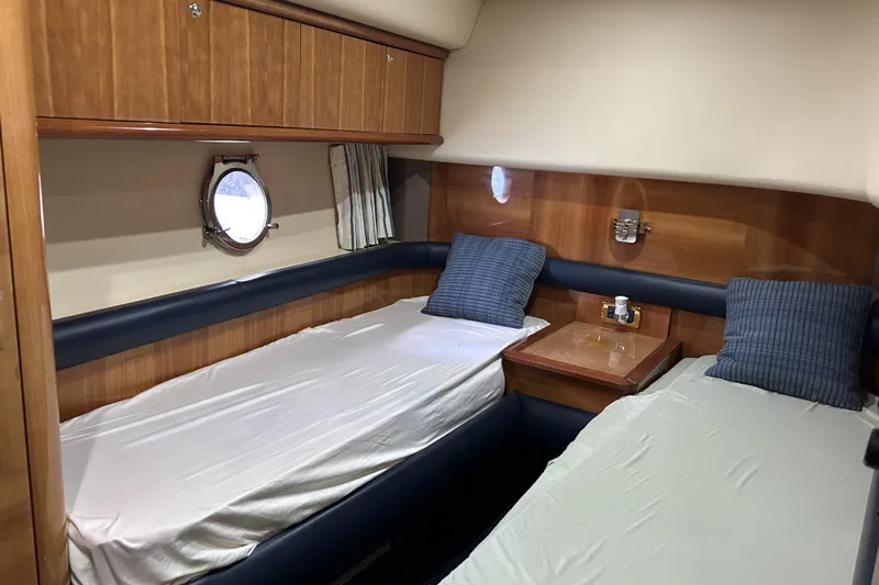 Yacht Photos Pics 2003 Azimut 55 yacht cabin with twin beds, wooden paneling, and porthole window.
