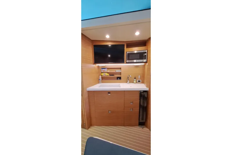  Yacht Photos Pics 2022 Scout 530 LXF yacht interior with kitchenette, featuring sink, microwave, and storage cabinets.