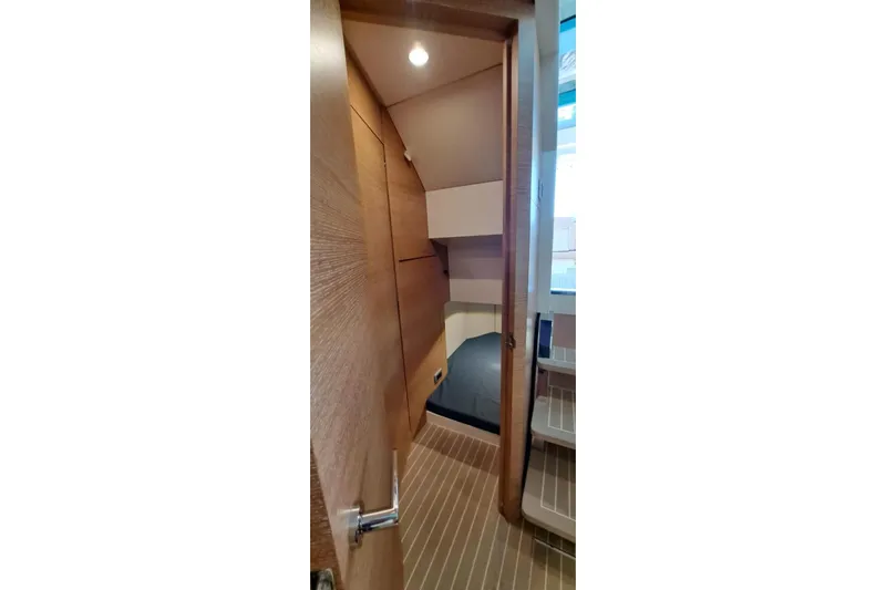  Yacht Photos Pics Interior cabin view of 2022 Scout 530 LXF boat, featuring wooden finishes and cozy sleeping area.