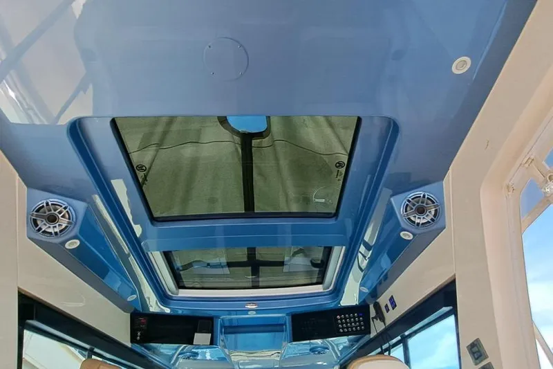  Yacht Photos Pics Interior view of 2022 Scout 530 LXF boat's sleek blue ceiling with speakers and skylight.