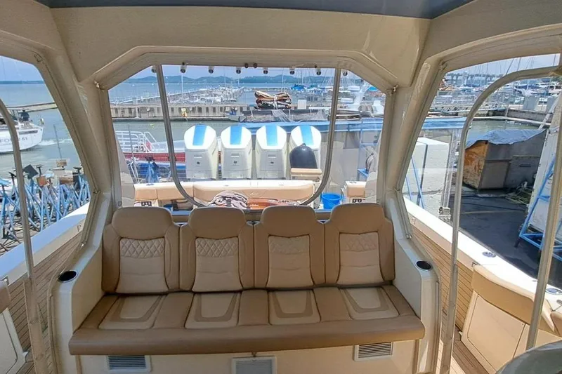  Yacht Photos Pics Interior view of 2022 Scout 530 LXF yacht with luxurious seating and marina backdrop.