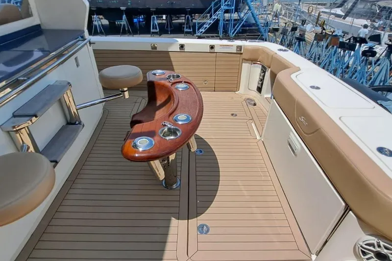  Yacht Photos Pics 2022 Scout 530 LXF boat deck with seating and wooden table, showcasing luxury design.