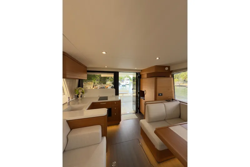 Waxing Gibbous Yacht Photos Pics Luxurious interior of 2024 Greenline 48 Fly yacht with modern kitchen and seating area.