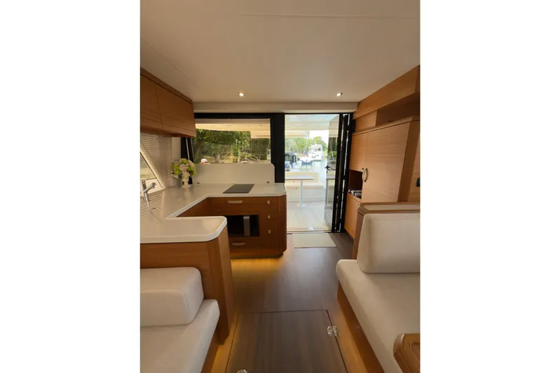 Waxing Gibbous Yacht Photos Pics Luxurious interior of 2024 Greenline 48 Fly yacht with modern kitchen and seating area.