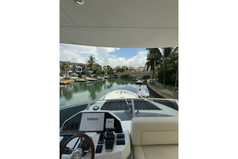 Waxing Gibbous Yacht Photos Pics 2024 Greenline 48 Fly yacht interior view with navigation system, overlooking serene waterfront homes.