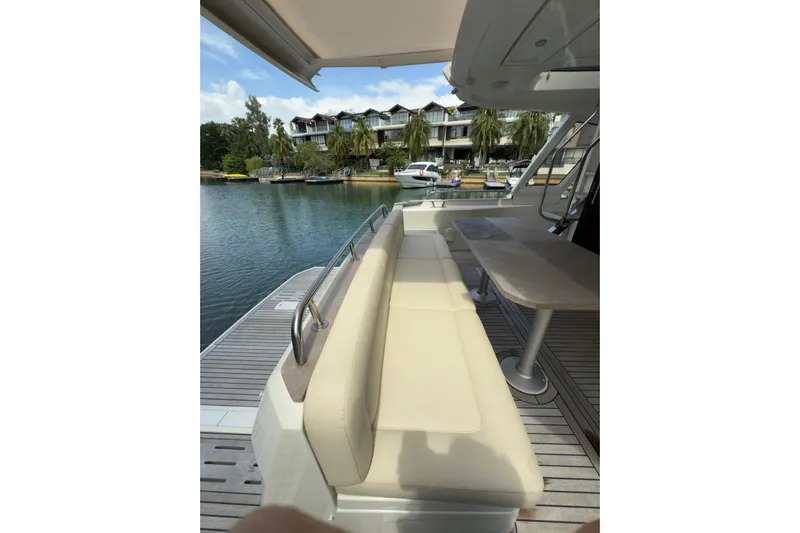 Waxing Gibbous Yacht Photos Pics 2024 Greenline 48 Fly yacht with outdoor seating and table by the water.