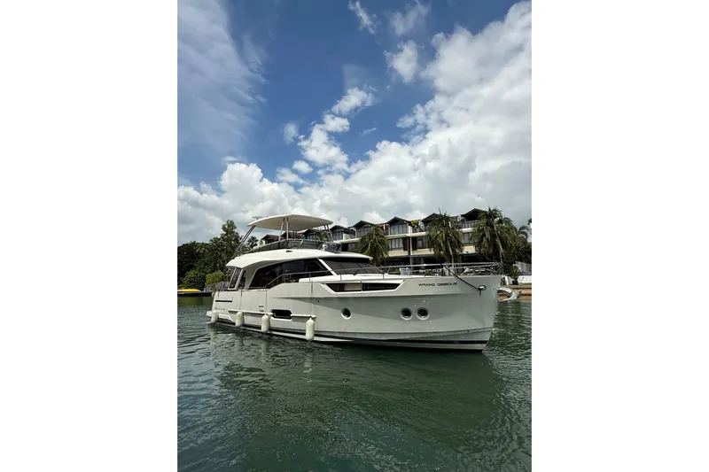 Waxing Gibbous Yacht Photos Pics 2024 Greenline 48 Fly yacht on calm water, with a scenic backdrop.