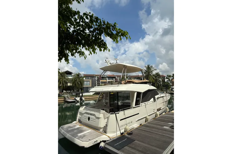 Waxing Gibbous Yacht Photos Pics 2024 Greenline 48 Fly yacht docked, surrounded by lush greenery and clear skies.