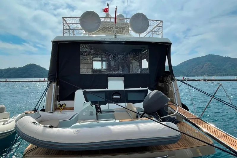  Yacht Photos Pics 2018 Absolute NAVETTA 58 yacht with inflatable boat, docked on a scenic waterfront.