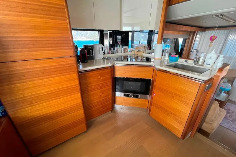  Yacht Photos Pics Luxurious kitchen interior of 2018 Absolute NAVETTA 58 yacht with wooden cabinetry and modern appliances.