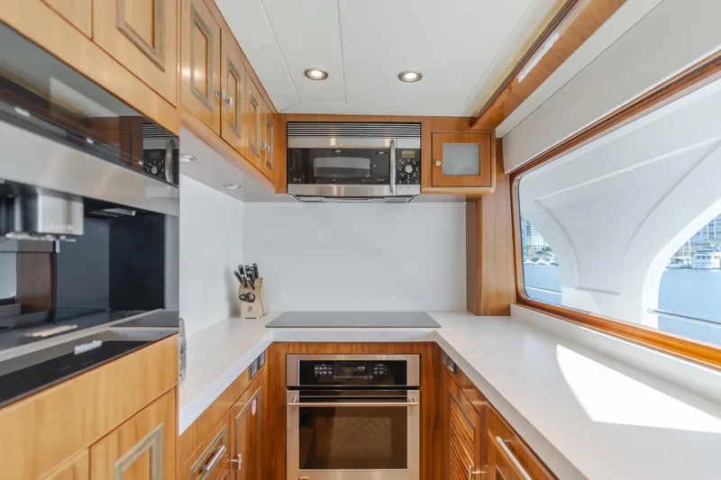White Lotus Yacht Photos Pics Luxurious kitchen in 2011 President Sterling Tri-Deck yacht with modern appliances and wood cabinetry.