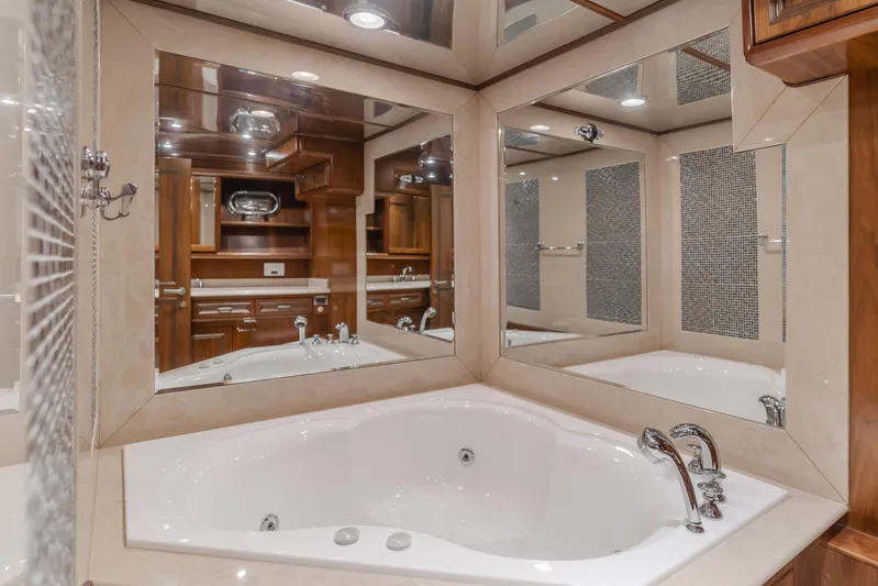 White Lotus Yacht Photos Pics Luxurious bathroom with corner jacuzzi tub and mirrored walls on a 2011 President Sterling Tri-Deck yacht.