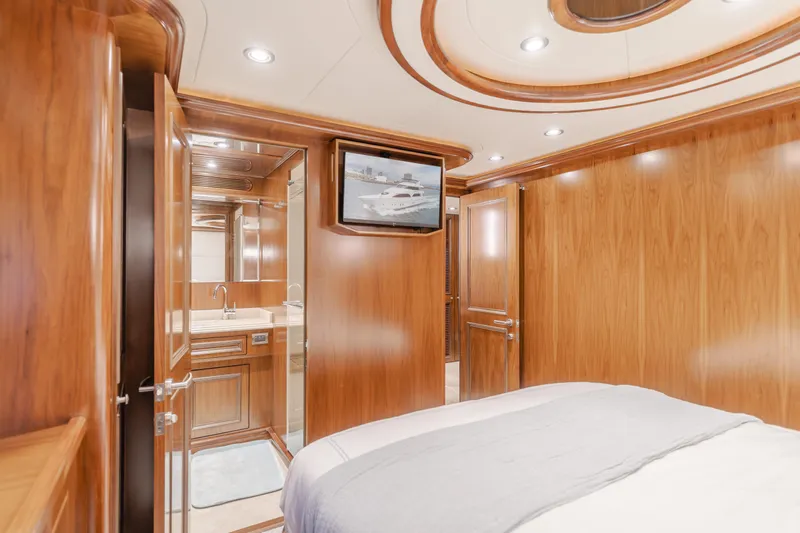 White Lotus Yacht Photos Pics Luxurious 2011 President Sterling Tri-Deck yacht bedroom with wood paneling and ensuite bathroom.