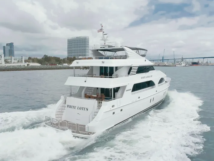 White Lotus Yacht Photos Pics Luxurious 2011 President Sterling Tri-Deck yacht cruising near city skyline and bridge.