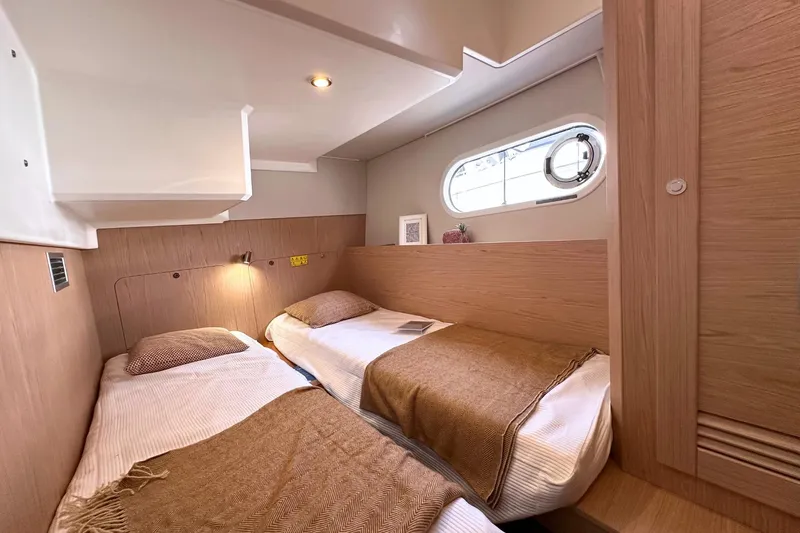  Yacht Photos Pics Cozy twin cabin in 2025 Beneteau Swift Trawler 41 Fly, featuring modern wood finishes.