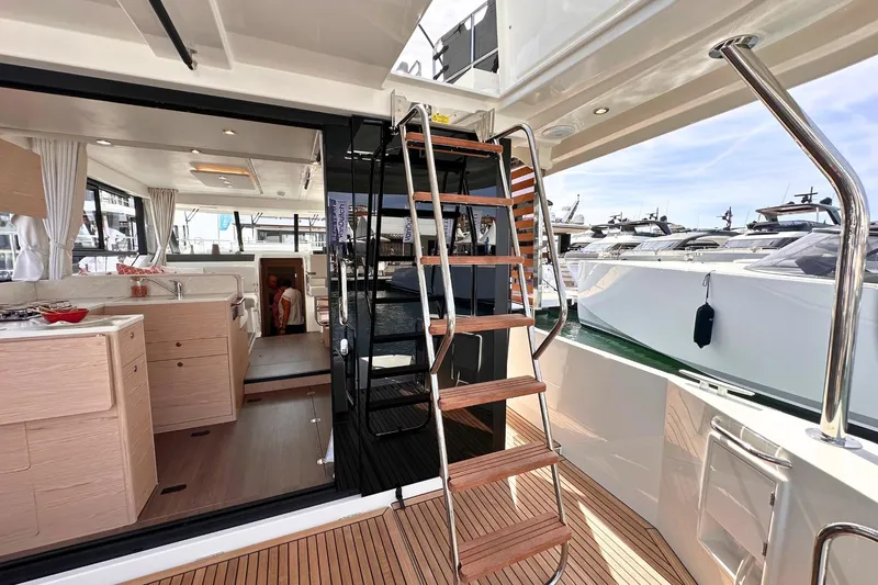  Yacht Photos Pics 2025 Beneteau Swift Trawler 41 Fly interior with wooden stairs and modern kitchen.