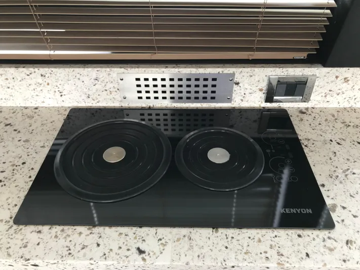 Forevermore Yacht Photos Pics Kenyon stovetop on Sea Ray L590 Fly yacht, 2016 model, with speckled countertop and blinds.