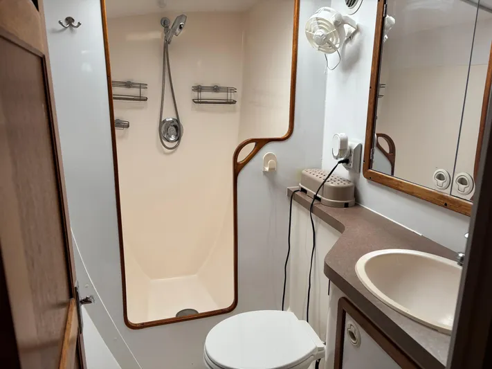 Making Memorie's Yacht Photos Pics Bathroom interior of a 1999 Manta 40 yacht, featuring shower, sink, and toilet.