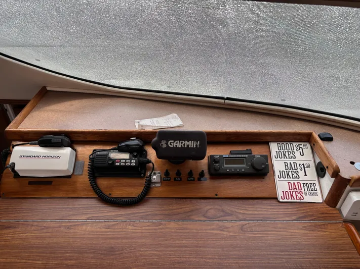 Making Memorie's Yacht Photos Pics Control panel of a 1999 Manta 40 boat with communication devices and humorous sign.