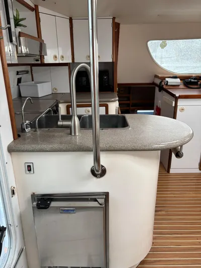 Making Memorie's Yacht Photos Pics Interior of 1999 Manta 40 yacht kitchen with modern sink and wooden flooring.