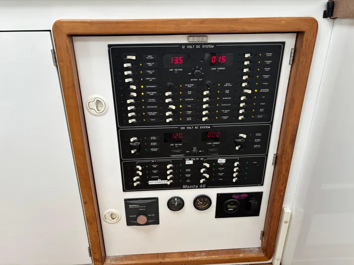Making Memorie's Yacht Photos Pics Electrical control panel of a 1999 Manta 40 boat, featuring 12V and 120V systems.