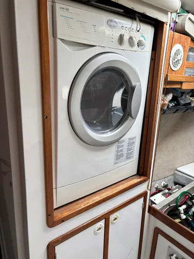 Making Memorie's Yacht Photos Pics Built-in washing machine on a 1999 Manta 40 boat, surrounded by wooden cabinetry.