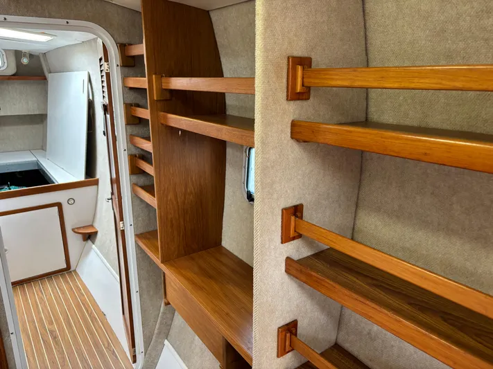 Making Memorie's Yacht Photos Pics Interior of 1999 Manta 40 sailboat with wooden shelves and cozy cabin design.