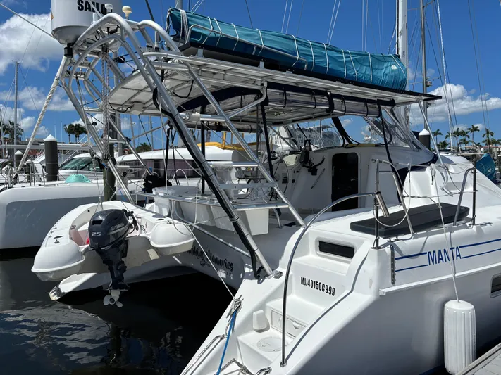 Making Memorie's Yacht Photos Pics 1999 Manta 40 catamaran docked, featuring a Yamaha outboard motor and blue canopy.