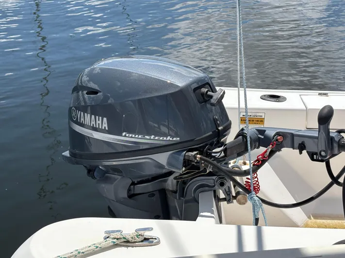 Making Memorie's Yacht Photos Pics Yamaha four-stroke outboard motor on a 1999 Manta 40 boat, docked on calm water.