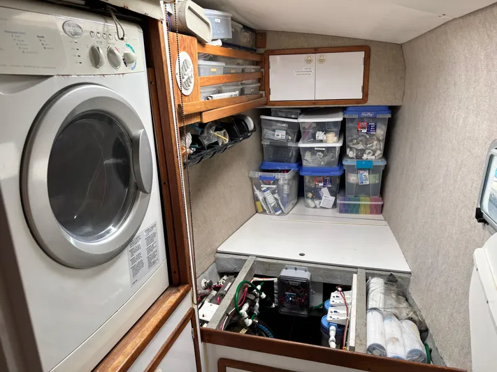 Making Memorie's Yacht Photos Pics Laundry and storage area on a 1999 Manta 40 yacht with organized bins and washer.
