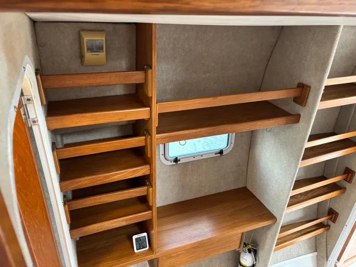 Making Memorie's Yacht Photos Pics Interior shelving of a 1999 Manta 40 boat with wooden shelves and a small window.