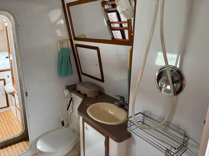 Making Memorie's Yacht Photos Pics Compact bathroom in a 1999 Manta 40 yacht with shower, sink, and toilet.