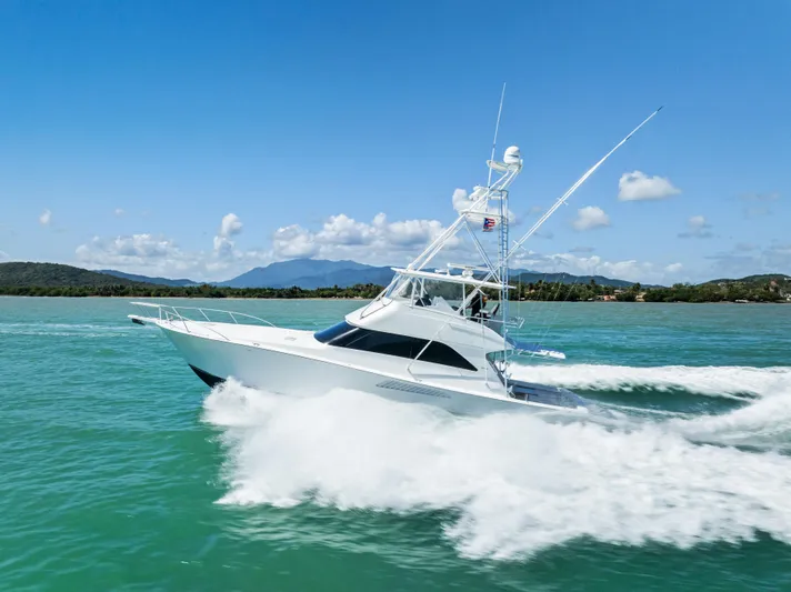 Ivelymar Yacht Photos Pics 2005 Viking 56 Convertible yacht cruising on turquoise waters under a clear blue sky.