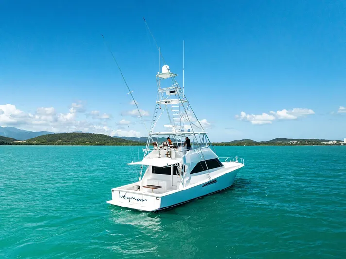 Ivelymar Yacht Photos Pics 2005 Viking 56 Convertible yacht on turquoise water under clear blue sky.