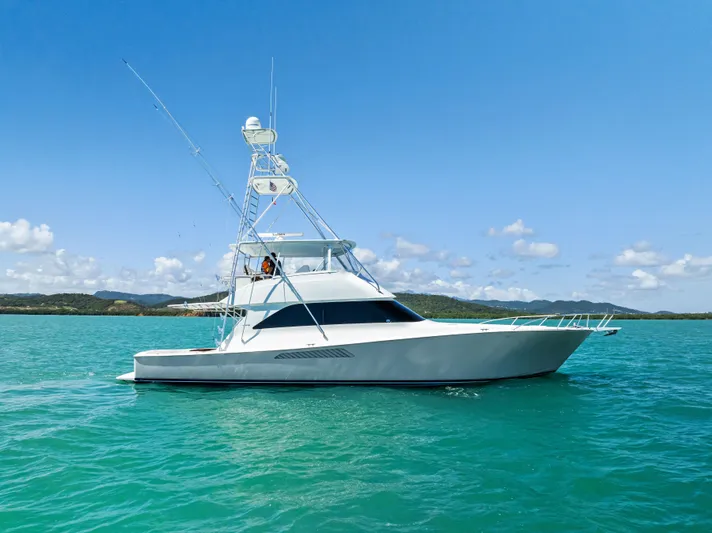 Ivelymar Yacht Photos Pics 2005 Viking 56 Convertible yacht on turquoise water under clear blue sky.