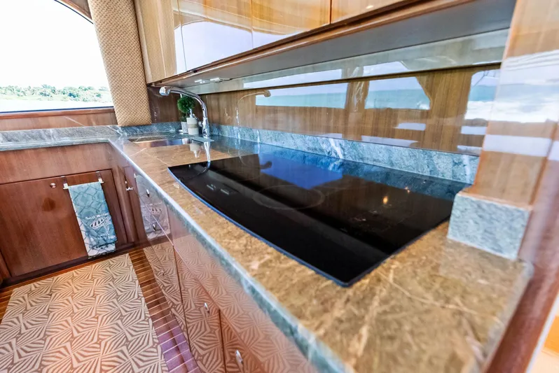 Ivelymar Yacht Photos Pics Luxurious kitchen interior of 2005 Viking 56 Convertible yacht with marble countertops.
