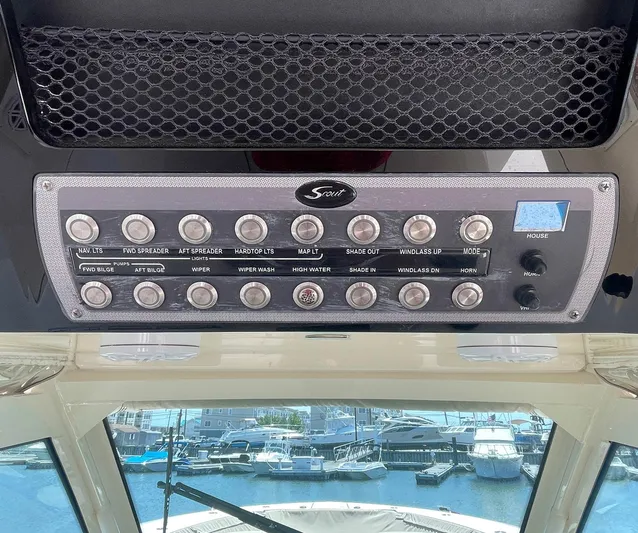 Shady Lady II Yacht Photos Pics Control panel of a 2019 Scout 380 LXF boat with various switches and marina view.