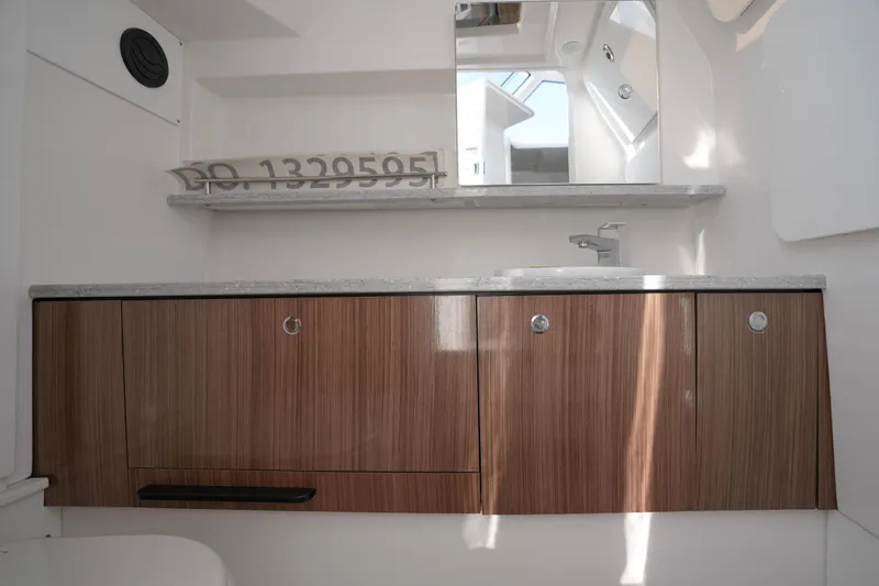  Yacht Photos Pics 2023 Everglades 340 Dual Console bathroom with wooden cabinets and modern sink.