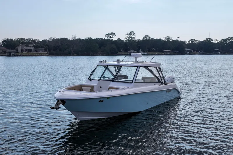  Yacht Photos Pics 2023 Everglades 340 Dual Console boat on calm water, surrounded by trees.