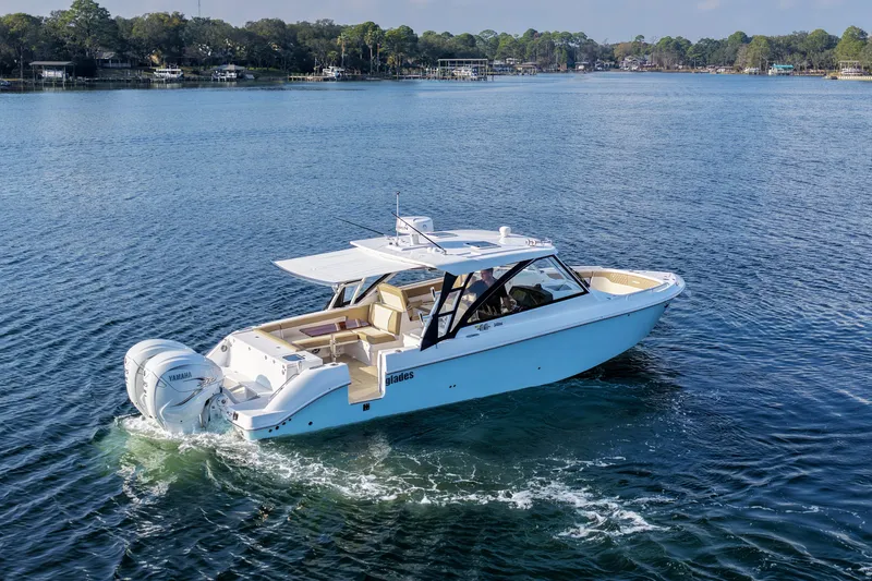  Yacht Photos Pics 2023 Everglades 340 Dual Console boat cruising on a serene lake.