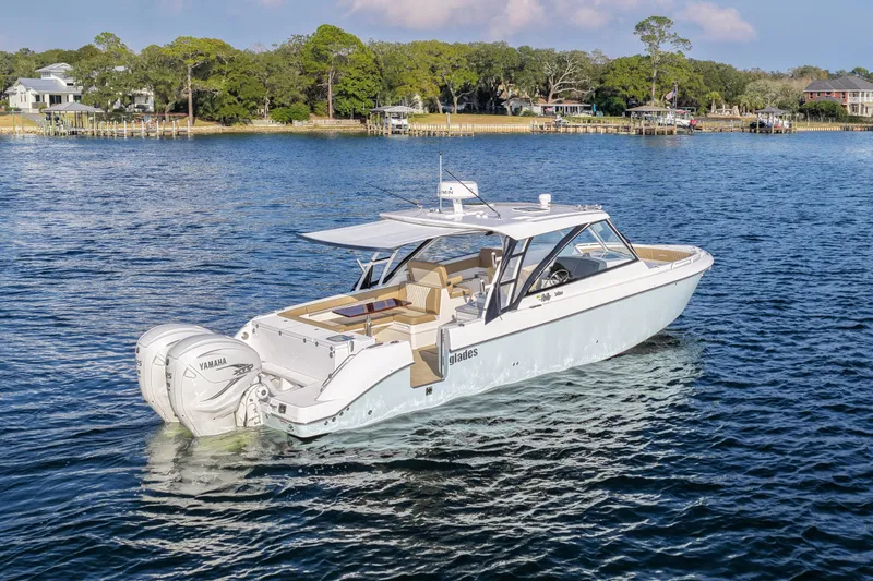  Yacht Photos Pics 2023 Everglades 340 Dual Console boat on serene water, showcasing sleek design and powerful engines.
