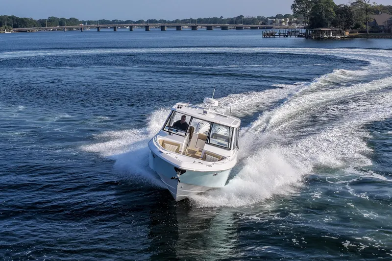  Yacht Photos Pics 2023 Everglades 340 Dual Console boat cruising on a scenic waterway.