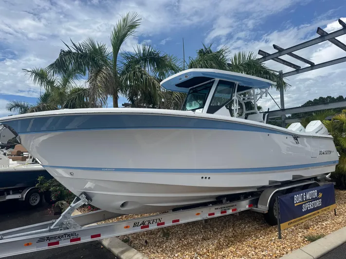  Yacht Photos Pics 2026 Blackfin 302 CC boat on trailer, surrounded by palm trees.
