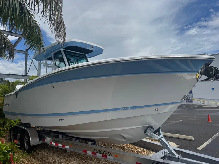  Yacht Photos Pics 2026 Blackfin 302 CC boat on trailer, parked outdoors under cloudy sky.