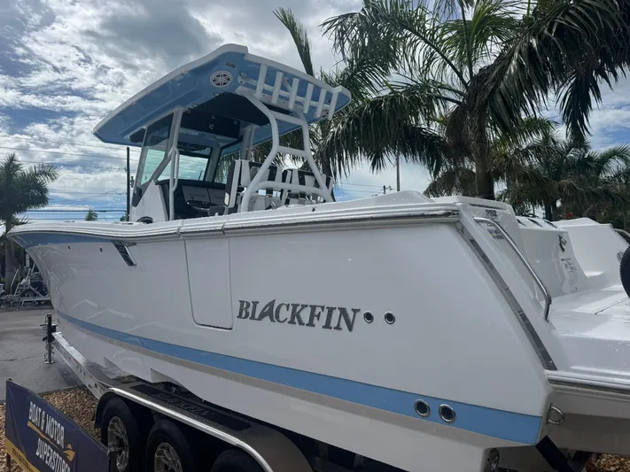  Yacht Photos Pics 2026 Blackfin 302 CC boat on trailer, surrounded by palm trees.