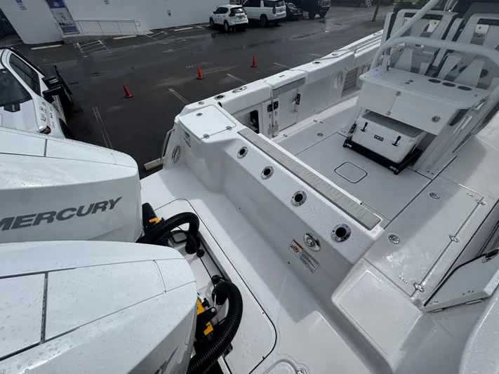  Yacht Photos Pics 2026 Blackfin 302 CC boat deck with Mercury engines, wet surface, and seating area.